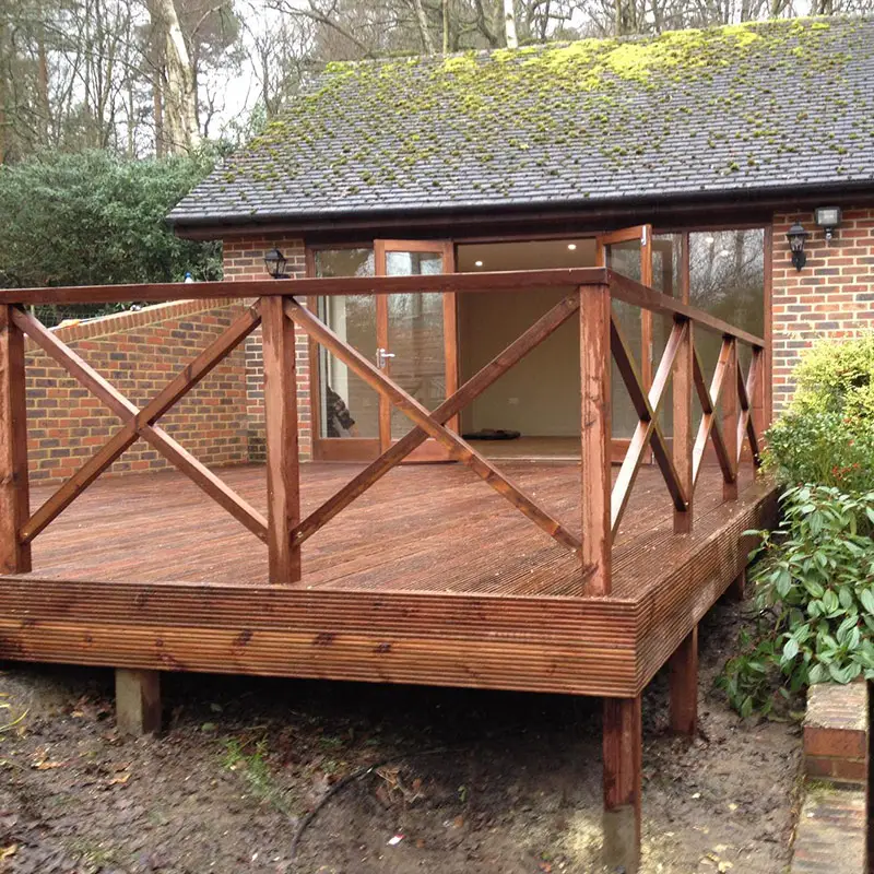 Raised decking costs: supports, edges and balustrades Raised timber deck with visible support posts and cross-braced timber balustrades